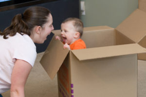 Photo of a mother and baby near moving boxes to discuss preparing to move.
