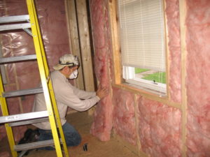 Photo of a man replacing home insulation.