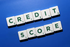 Scrabble tiles spelling out "Credit score" to discuss how to improve credit scores.