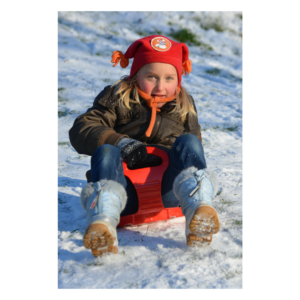 Photo of a girl sledding; sledding is one of the upcoming Shorewood events.