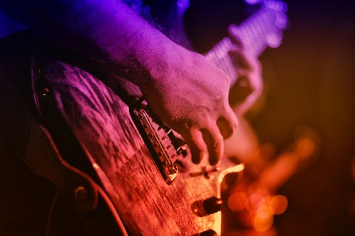 Closeup of a someone playing a guitar; a 60's music concert is one of the November 2019 events coming up.