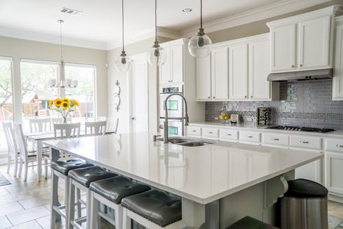 Light, bright and clean kitchen with white cabinets and white countertops.